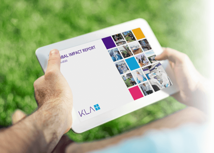 手持平板电脑显示KLA全球影响报告的人。